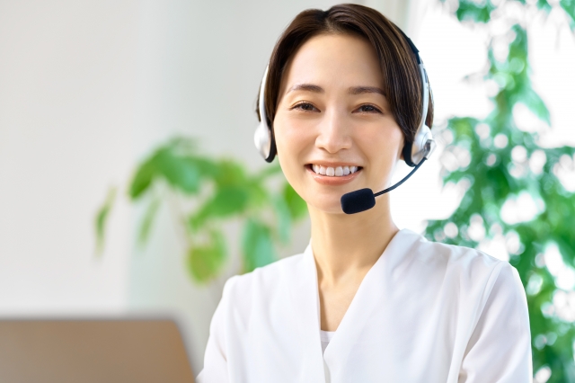 庭木の伐採について電話で問い合わせる女性